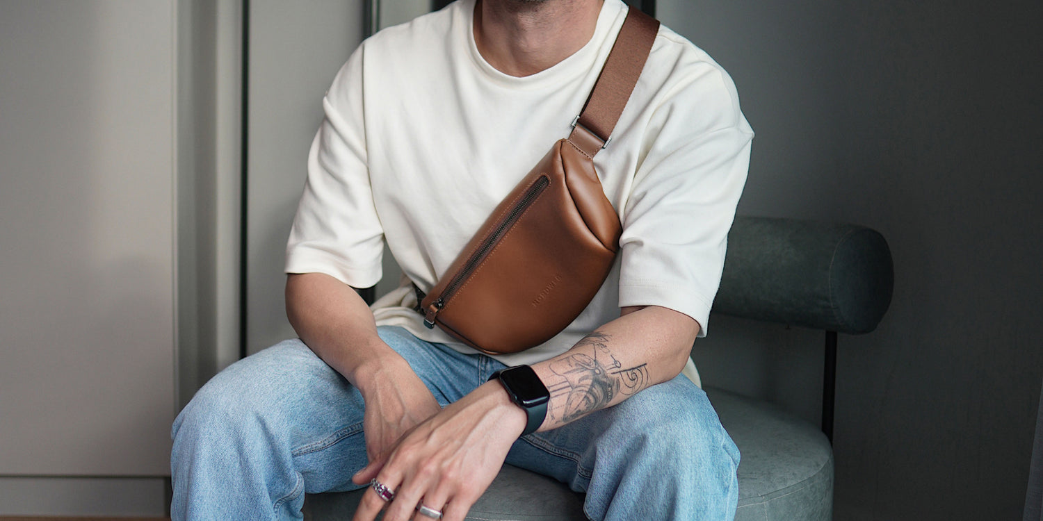 Homem com look casual vestindo camiseta branca e jeans, usando a Sling Bag Pulse NW112 Nordweg de couro caramelo, estilo urbano e minimalista.