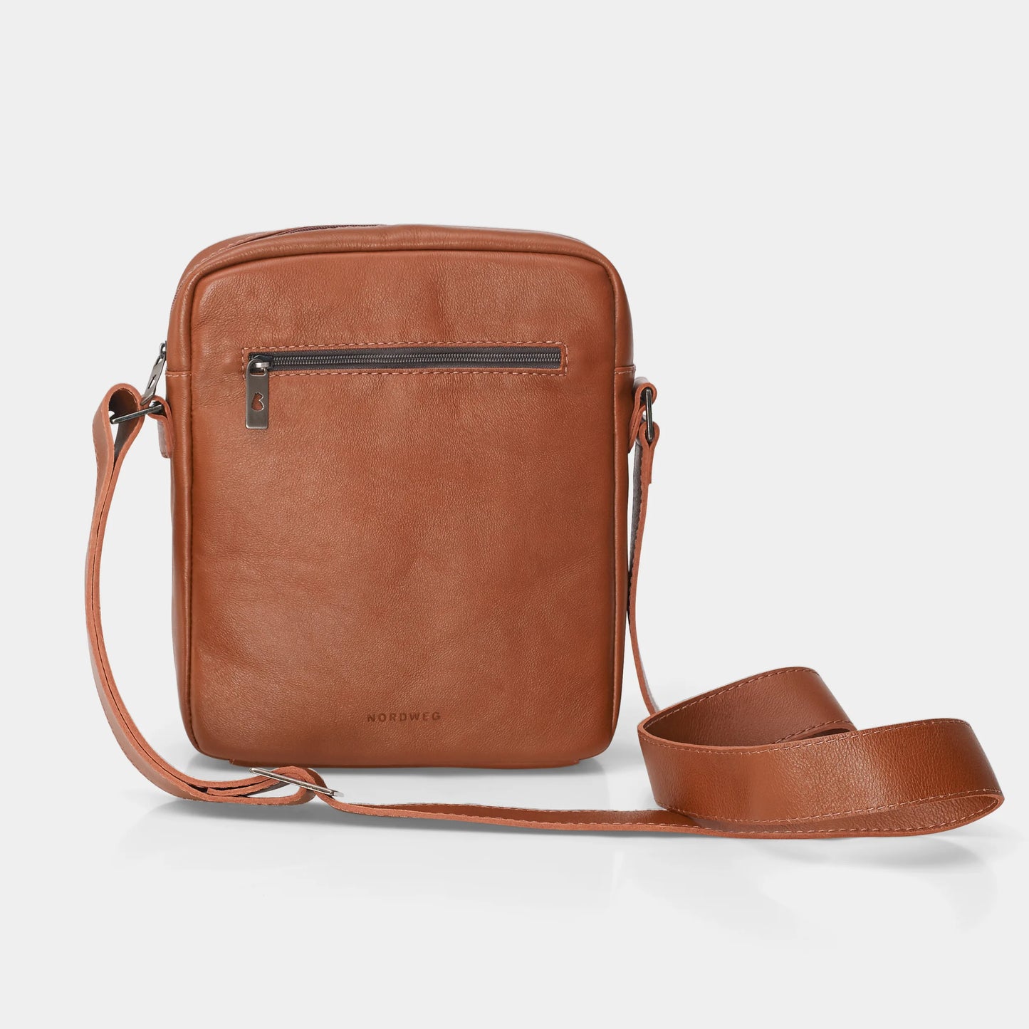 Vista frontal da Bolsa de couro para iPad Nômade NW091A na cor caramelo, com bolso frontal de zíper, logo Nordweg gravado no couro e alça transversal ajustável