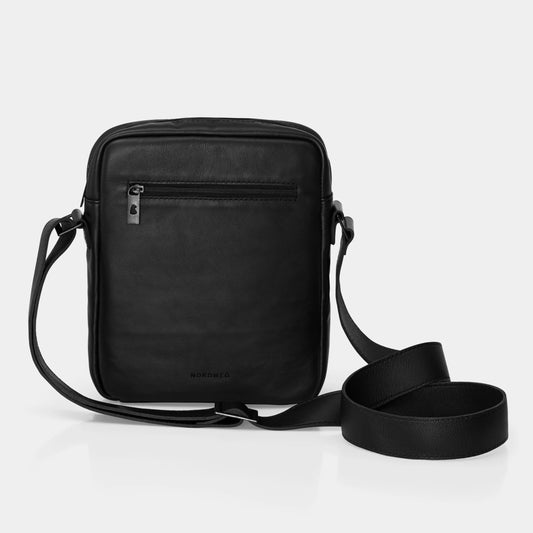 Vista frontal da Bolsa de couro para iPad Nômade NW091A na cor preto, com bolso frontal de zíper, logo Nordweg gravado no couro e alça transversal ajustável